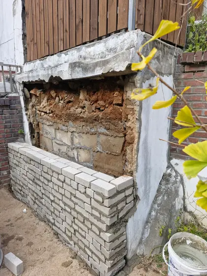 떨어지는 겉면을 걷어내고 그 앞에 벽돌을 새로 쌓는 작업